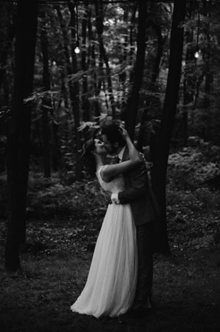 Un couple de mariés qui s'embrasse tendrement dans une forêt