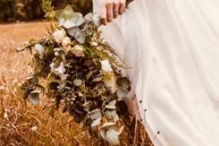 Bouquet d'une mariée qui marche dans un champs