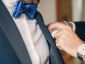 HOMME PORTANT UN NOEUD PAPILLON QUI MET UNE POCHETTE