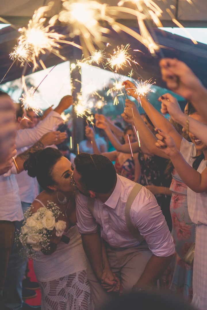 Couple de mariés qui s'embrassent devant leurs invités