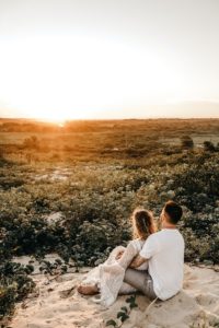 COUPLE QUI REGARDE UN COUCHER DE SOLEIL SUR UNE MONTAGNE