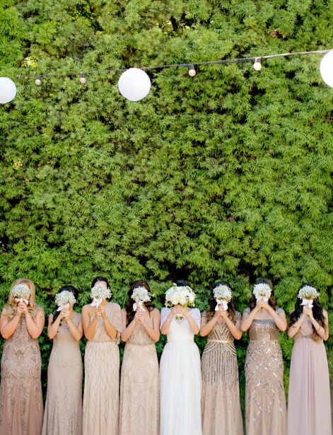 Groupe de demoiselle d'honneur et mariée qui cachent leur visage avec un bouquet de fleur