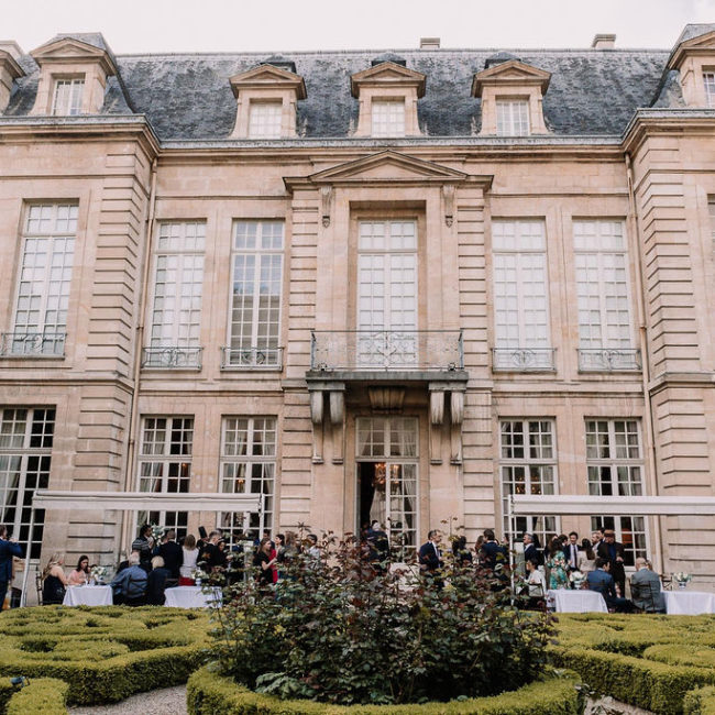 Devanture d'un hôtel pour une réception de mariage avec des buissons, des arbres