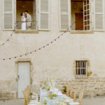 couple de mariés à la fenêtre d'un domaine